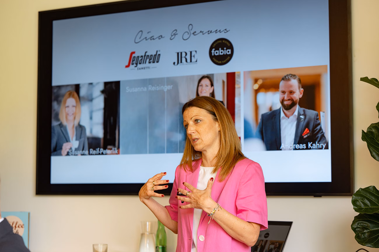 Vortragende vor einem Bildschirm bei der Kaffeeschulung im Rahmen des JRE Servicetages